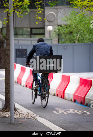 UberEATS cycle delivery courier in London, Ubereats is a take away food service which can be ordered from a Smartphone Stock Photo