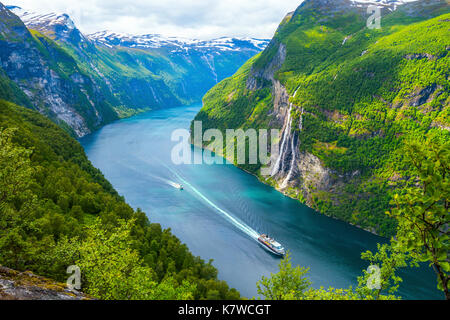 view to the Seven Sisters waterfall and the Geirangerfjorden with a cruise ship of Hurtigruten and a ferry, mountain panorama, Norway Stock Photo