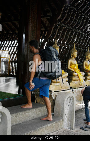 A backpacking tourist entering the main hall at the Seema Malaka Temple ( Simamalaka Shrine) ,situated on a small island on Lake Beira and close to Stock Photo