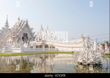 The bridge of the 'Cycle of Rebirth' leading to the Gate of Heaven and into the Ubosot at Wat Rong Khun (White Temple). Chiang Rai Province, Thailand Stock Photo