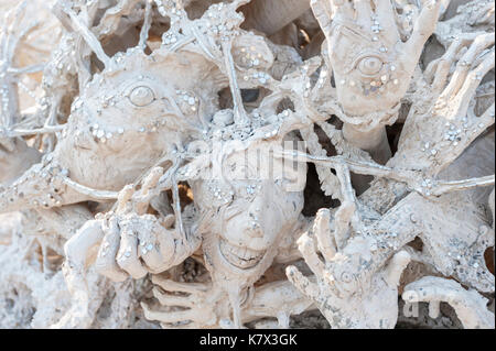 Twisted Face and hand sculptures at The bridge of the 'Cycle of Rebirth' at Wat Rong Khun (White Temple). Chiang Rai Province, Thailand Stock Photo