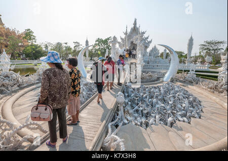 Reaching hand sculptures symbolizing unrestrained desire at The bridge of the 'Cycle of Rebirth' at Wat Rong Khun (White Temple). Chiang Rai, Thailand Stock Photo