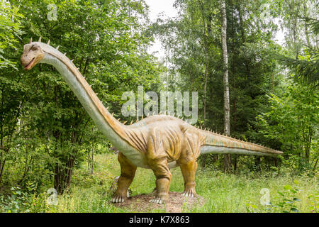 Statue of realistic dinosaur in a wild forest Stock Photo