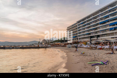 Juan les Pins, France - September 2nd, 2017: Holidaymakers enjoy an evening sunset at Juan les Pins, France. The city is famous for its jazz festival Stock Photo