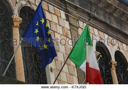 EU and Italian flags side by side outside an administrative building in Italy Stock Photo
