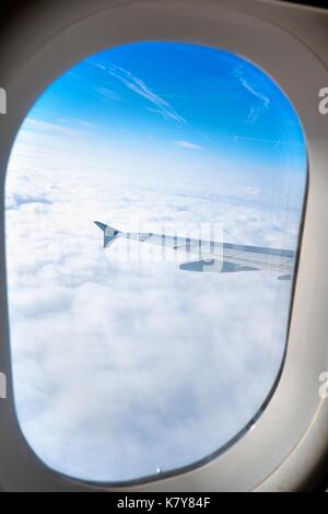 View from aircraft window of wing and white clouds Stock Photo