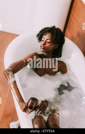 Top view at young afro american young woman laying in bath with foam Stock Photo