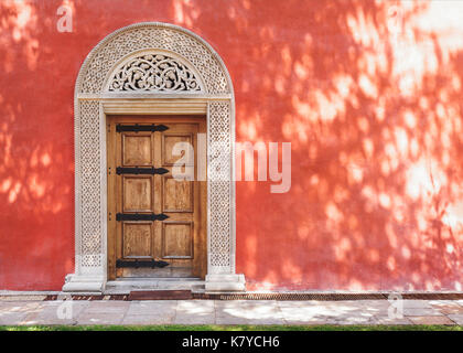 Zica monastery, 13th century, carved medieval stone door in the red stucco wall, architecture detail
