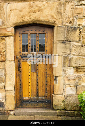 Medieval Cathedral Door of Honey Colored Oak with Massive Stone Lintel, Decorative Iron Studs and Hardware Stock Photo