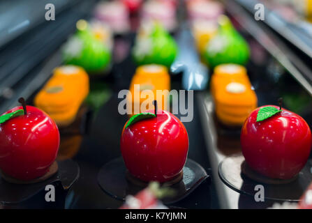 An apple-shaped mirror glaze mousse cake in a refridgerator in a cafe. Stock Photo