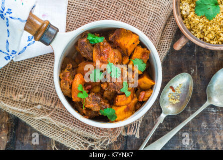Maroccan lamb tajine with couscous garnished with fresh coriander leaves - high angle view Stock Photo
