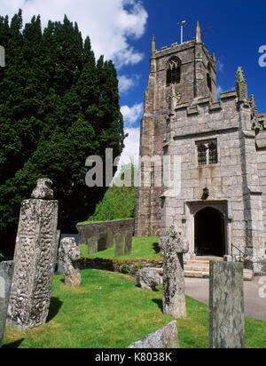 View N of C14th tower & C15th two-storey embattled porch of Parish Church of St Anietus, St Neot, Cornwall. C10th decorated Hiberno-Saxon cross-shaft. Stock Photo