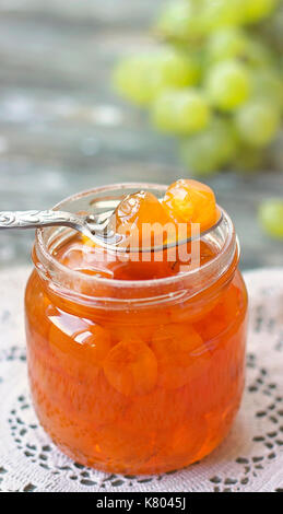 Slatko - white grape jam (sweet), traditional serbian desert; white grapes in syrup in a glass jar; close up, vertical view Stock Photo