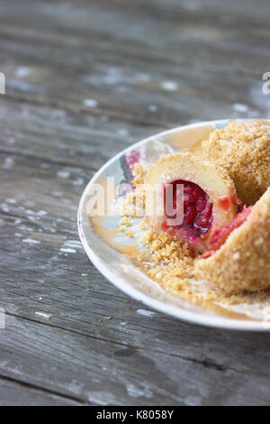 Plum dumplings on the colorful plate on wooden table Stock Photo