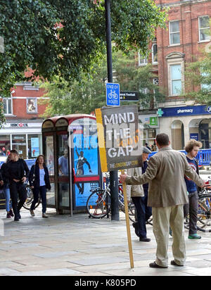 Evangelist in London high street with 'Mind the God Gap' sign Stock Photo