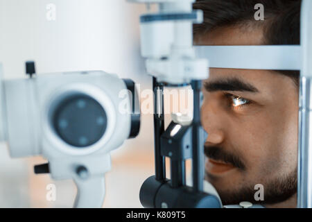 Patient or customer at slit lamp at optometrist or optician