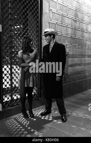 Black and white film noir image of man and woman in lamplight Stock Photo