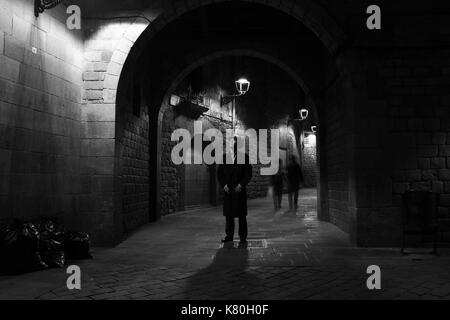 Black and white film noir image of man and woman in lamplight Stock Photo