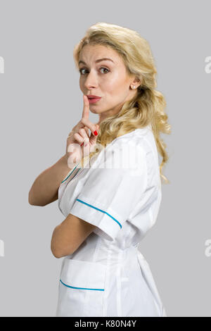Beautiful young nurse gesturing silence. Stock Photo