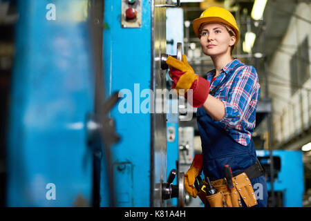 Young Machine Operator Concentrated on Work Stock Photo