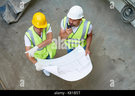 Construction Workers Wrapped up in Discussion Stock Photo