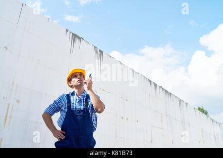 Handsome Construction Worker Using Walkie-Talkie Stock Photo
