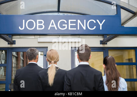 Rear View Of Businesspeople Standing Outside Job Agency Stock Photo
