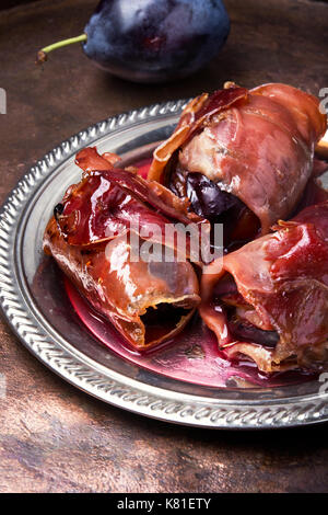 spicy spanish dish jamon with plum on a retro background Stock Photo