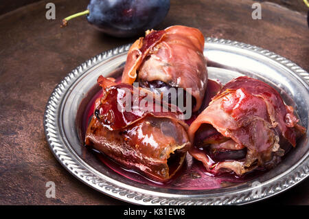 spicy spanish dish jamon with plum on a retro background Stock Photo