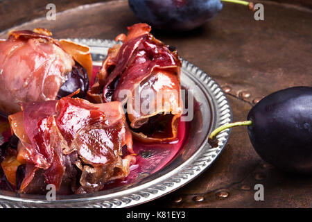 spicy spanish dish jamon with plum on a retro background Stock Photo