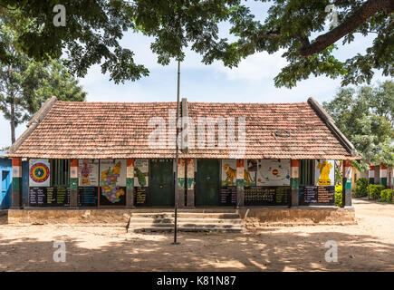 Mysore, India - October 27, 2013: Government higher primary school building under red tiled roof and with walls painted with colorful images and texts Stock Photo