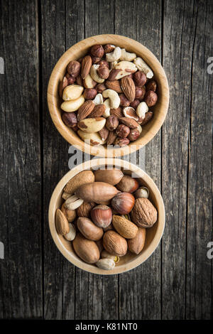 Different types of nuts. Hazelnuts, walnuts, almonds, brazil nuts and pistachio nuts in wooden bowl. Stock Photo
