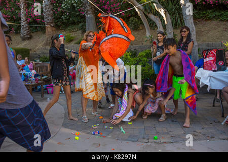 Hispanic girl, hitting a pinata, pinata filled with candy sweets and toys, birthday party, Castro Valley, Alameda County, California, United States Stock Photo