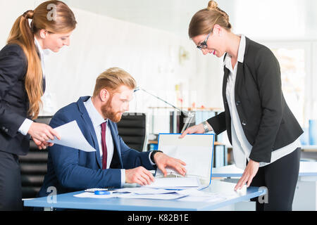 Manager checking documents in front of assistants Stock Photo