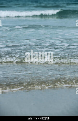 The sea gently breaking onto a sandy beach Stock Photo