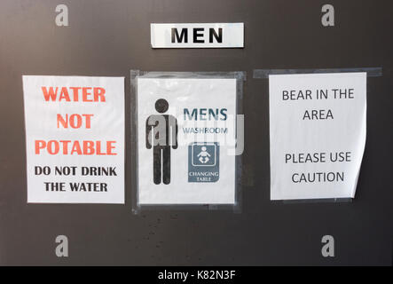 Okanagan valley British Columbia Canada 2017. A caution sign on a remote highway rest stop washroom door warning visitors of bears in the area Stock Photo