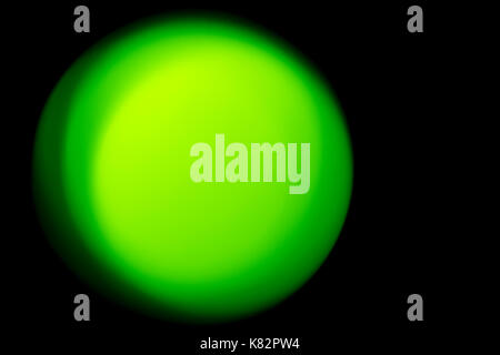 Blur effect in the form of a green ball on a black background as an abstraction. Stock Photo
