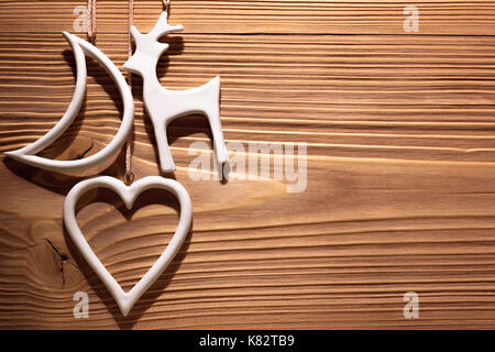 White Christmas decorations hanging on wooden wall. Background with space for text. Stock Photo