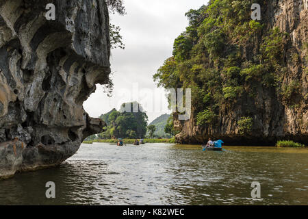 NINH BINH, VIETNAM - 5/6/2016: Several boats on the Ngo Dong River, near Tam Coc village, at the Trang An UNESCO World Heritage site in Ninh Binh, Vie Stock Photo