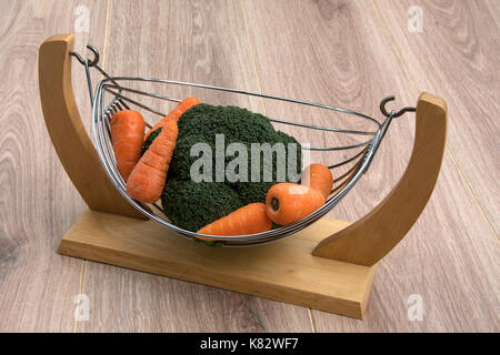 Broccoli and carrots in a wood and wire basket.cookery Stock Photo