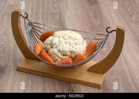 Cauliflower and carrots in a wood and wire basket. Stock Photo