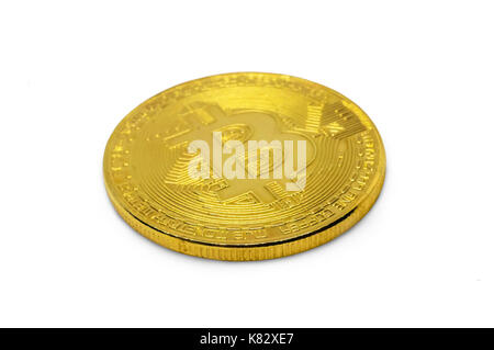 golden bitcoin isolated on white background. shiny gold coin with the bitcoin symbol lying on its side on a white table close-up Stock Photo