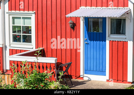 Karlskrona, Sweden - August 28, 2017: Travel documentary of city allotment area. Detail of red allotment cabin with blue kitchen door and balcony. Stock Photo