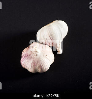 Fresh garlic bulbs and cloves grouped on black background. Flat lay ...