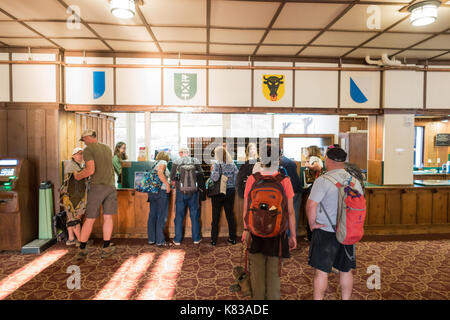 Guests waiting in line at the reception to check in into the Swiftcurrent Lodge / hotel in Many Glacier National Park, Montana Stock Photo