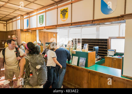 Guests waiting in line at the reception to check in into the Swiftcurrent Lodge / hotel in Many Glacier National Park, Montana Stock Photo