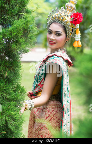 Portrait of Thai young lady wearing Thai traditional dress in the garden Stock Photo