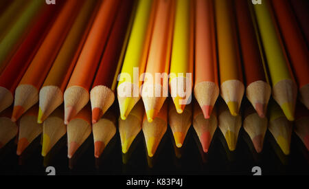 Yellow and Orange Pencils with Reflection on Black Background Stock Photo