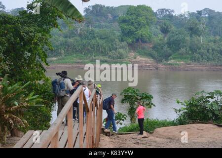 Tourists board a motor boat to a lodge in the Amazon rainforest. Tambopata river, Puerto Maldonado, Peru Stock Photo