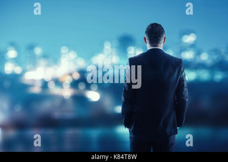 man in suit looking to night city Stock Photo